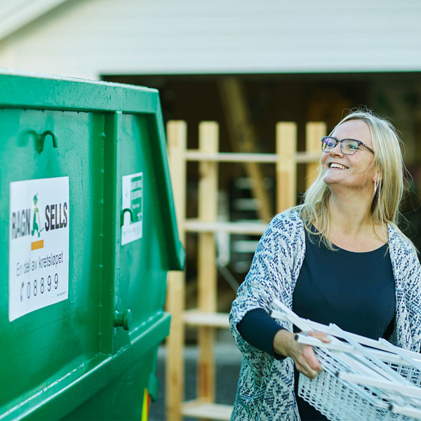 Kvinner som kaster avfall i en Ragn-Sells søppelcontainer.