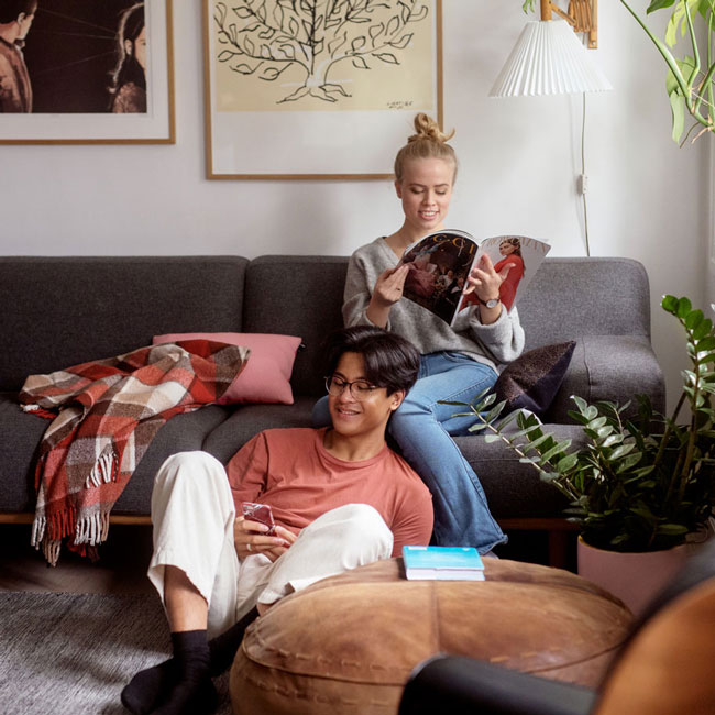 Ung par som bor i en Usbl forvaltet bolig leser sammen i stua. 